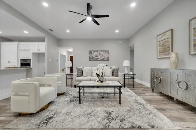 living room with visible vents, a ceiling fan, recessed lighting, light wood-style floors, and baseboards