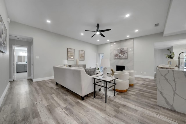 living area featuring recessed lighting, light wood finished floors, visible vents, baseboards, and ceiling fan
