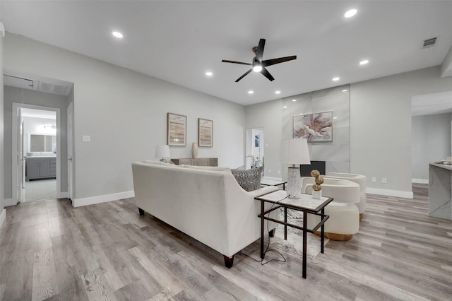 living room with visible vents, a ceiling fan, and baseboards
