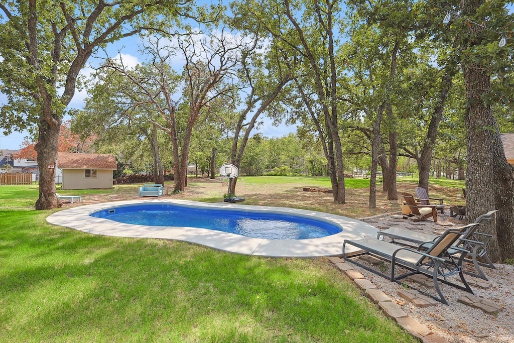 view of swimming pool featuring a lawn