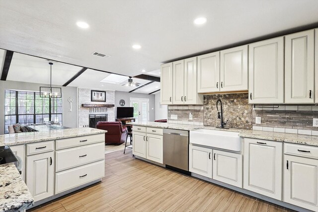 kitchen featuring visible vents, open floor plan, decorative backsplash, a fireplace, and stainless steel dishwasher