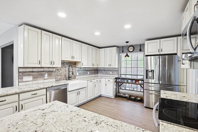 kitchen with white cabinetry, stainless steel appliances, and a sink