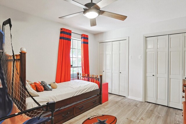 bedroom featuring baseboards, multiple closets, wood finished floors, and a ceiling fan