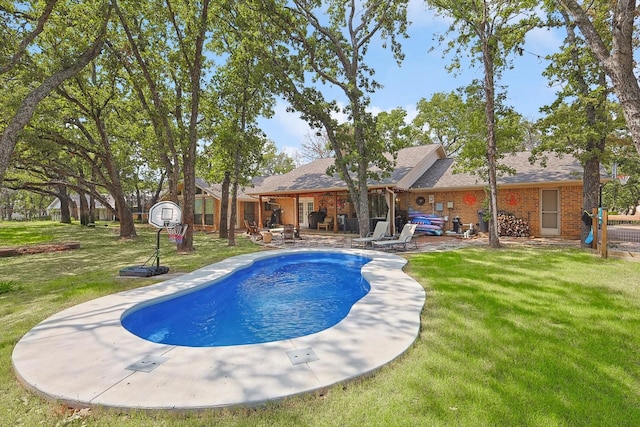 outdoor pool featuring a lawn and a patio