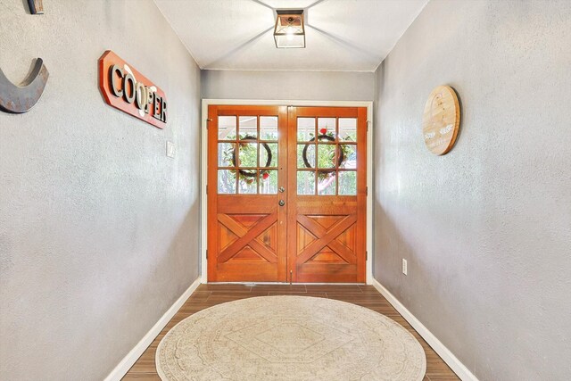 hall featuring baseboards and a textured wall