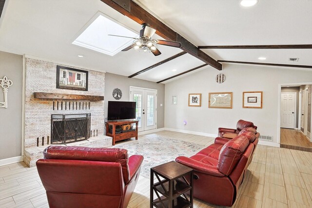 living room with visible vents, baseboards, lofted ceiling with skylight, french doors, and a fireplace