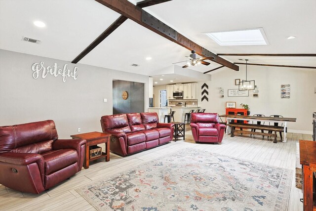 dining room featuring lofted ceiling with skylight, ceiling fan with notable chandelier, recessed lighting, baseboards, and a brick fireplace