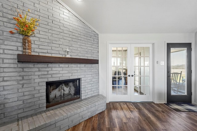 unfurnished living room featuring french doors, a fireplace, lofted ceiling, and wood finished floors