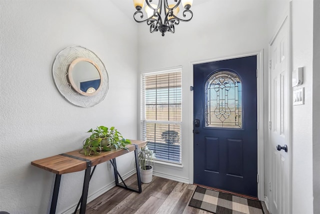 foyer featuring a chandelier, baseboards, and wood finished floors