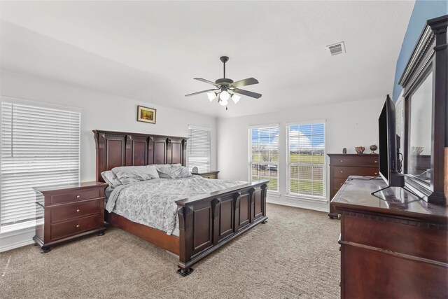 bedroom with visible vents, light carpet, and a ceiling fan