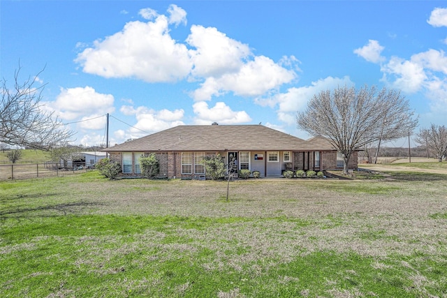 back of property with a yard, brick siding, and fence