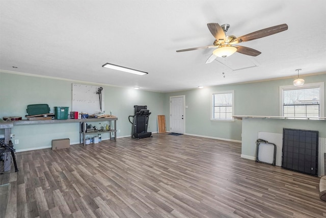 interior space featuring baseboards, wood finished floors, and ornamental molding