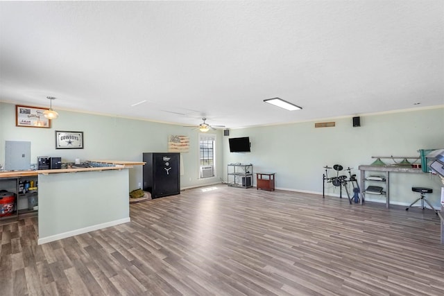 interior space with crown molding, baseboards, butcher block countertops, wood finished floors, and a ceiling fan