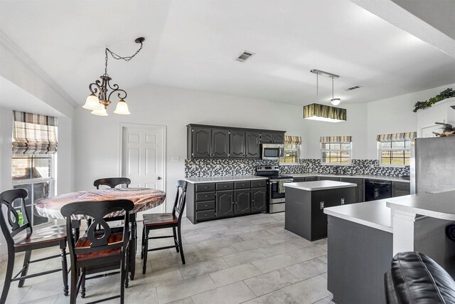 kitchen with decorative backsplash, appliances with stainless steel finishes, a kitchen island, and light countertops