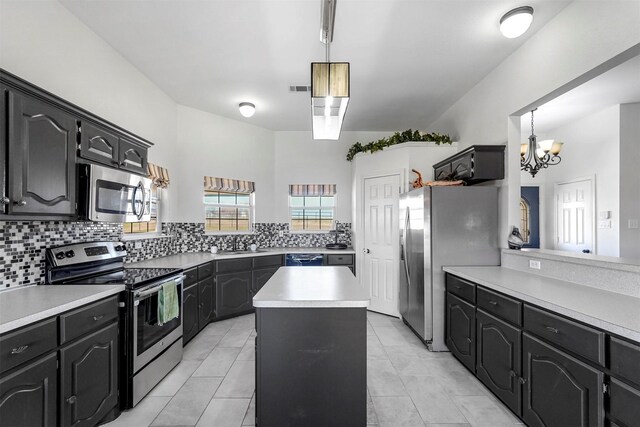 kitchen featuring light countertops, a kitchen island, tasteful backsplash, and stainless steel appliances