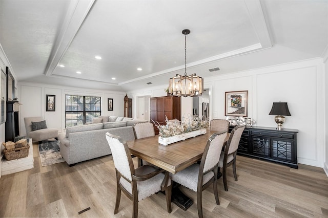 1605 Tampico Dr, Plano, TX 75075 - dining area with light wood-style floors, a chandelier, a decorative wall, a tray ceiling, and recessed lighting