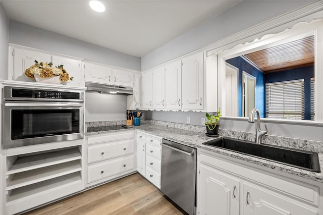 1605 Tampico Dr, Plano, TX 75075 - kitchen with stainless steel appliances, under cabinet range hood, white cabinetry, light wood-style flooring, and recessed lighting