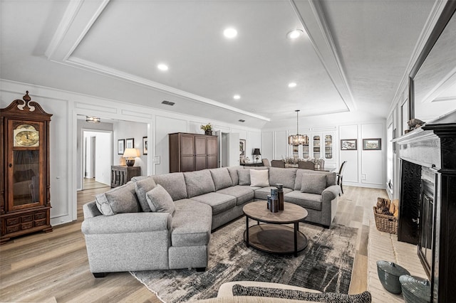 1605 Tampico Dr, Plano, TX 75075 - living room with a decorative wall, light wood-style flooring, a high end fireplace, crown molding, and a chandelier