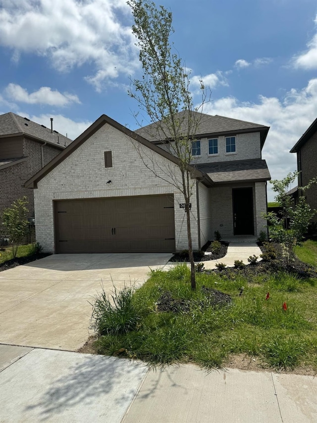 view of front of home featuring brick siding, driveway, and a garage