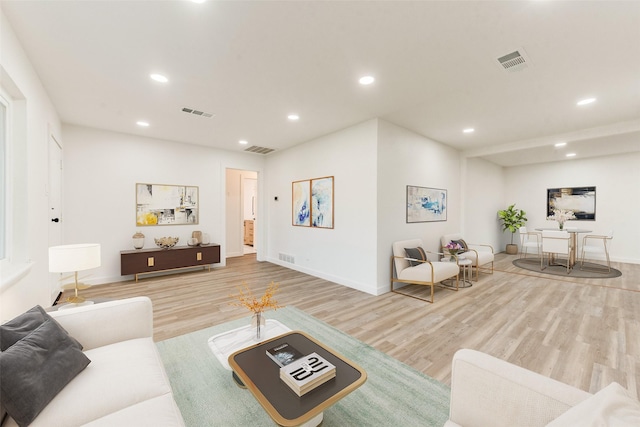 living area with recessed lighting, wood finished floors, and visible vents