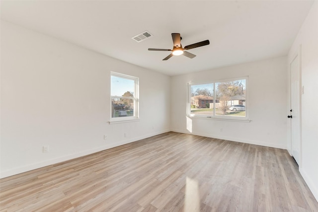 spare room featuring visible vents, baseboards, light wood-style floors, and a ceiling fan