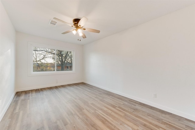 unfurnished room with light wood-style flooring, a ceiling fan, visible vents, and baseboards