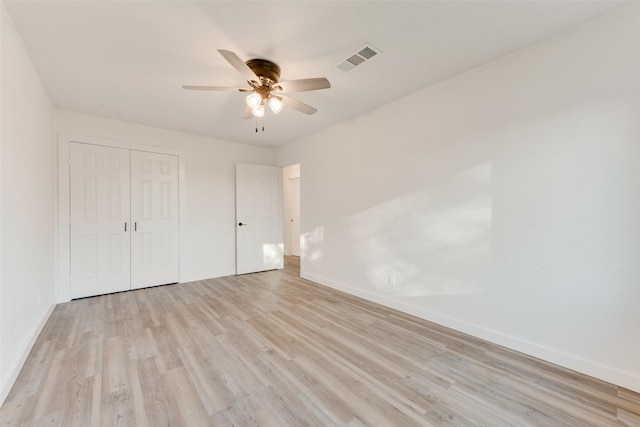 unfurnished bedroom with baseboards, visible vents, a closet, and light wood-type flooring