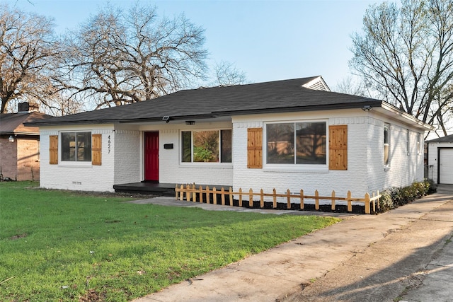 view of front facade with crawl space, a front lawn, brick siding, and an outdoor structure