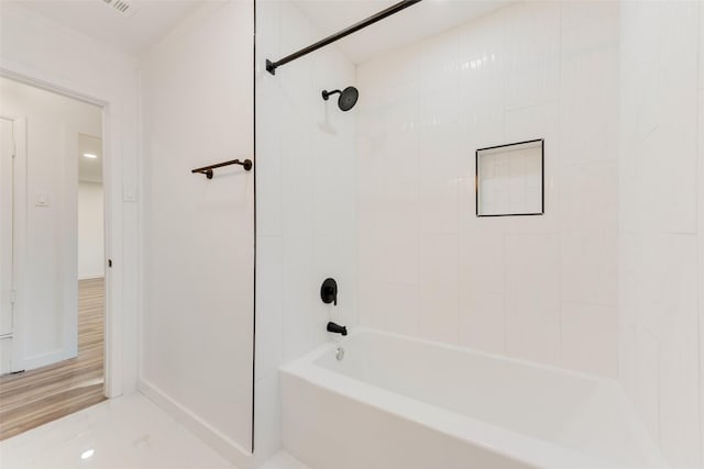 bathroom featuring baseboards and bathtub / shower combination