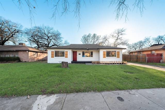 view of front facade with a front lawn and fence