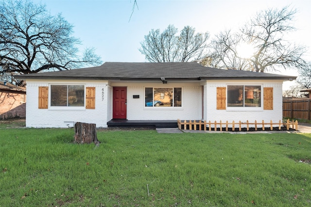 single story home featuring brick siding, a front lawn, and fence