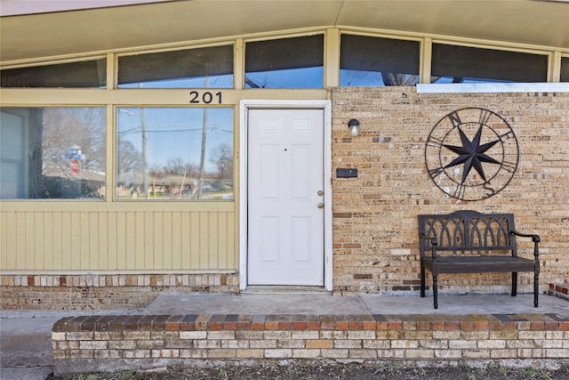 view of exterior entry with brick siding