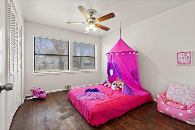 bedroom featuring visible vents, wood finished floors, a closet, baseboards, and ceiling fan