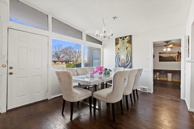 dining area featuring visible vents, a textured ceiling, wood finished floors, an inviting chandelier, and lofted ceiling