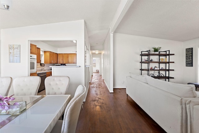 dining room with a textured ceiling and dark wood-style flooring