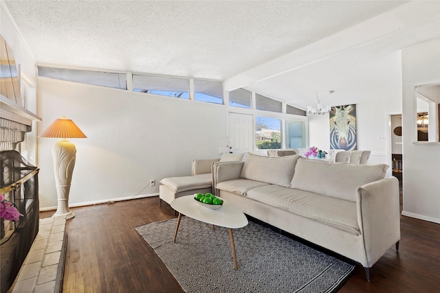 living area featuring a notable chandelier, a textured ceiling, hardwood / wood-style floors, baseboards, and vaulted ceiling with beams