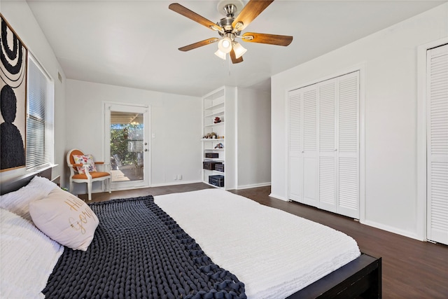 bedroom with ceiling fan, baseboards, dark wood-style floors, and multiple closets