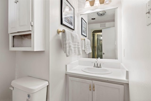 full bath with an enclosed shower, toilet, vanity, and visible vents