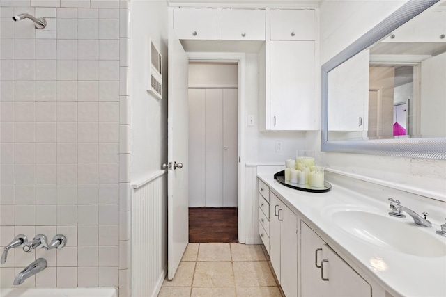 bathroom with tile patterned floors, washtub / shower combination, and vanity