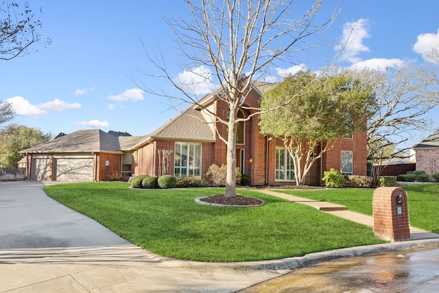 view of front of home with driveway, a front lawn, fence, a garage, and brick siding