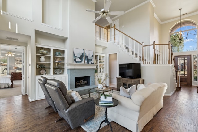 living area featuring visible vents, crown molding, dark wood-type flooring, and built in features