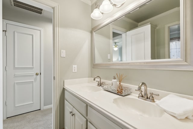 full bath with double vanity, visible vents, crown molding, and a sink