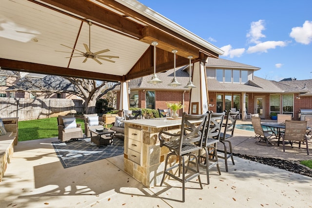 view of patio / terrace with fence, a fenced in pool, ceiling fan, outdoor lounge area, and outdoor dry bar