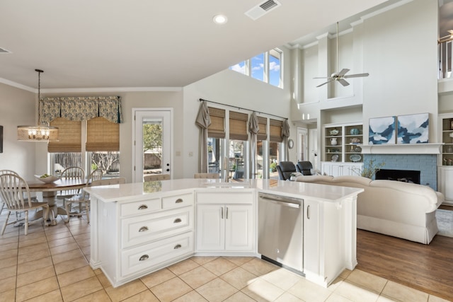 kitchen with visible vents, ornamental molding, open floor plan, light countertops, and dishwasher