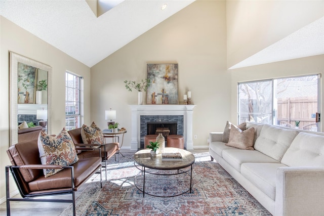 living room with wood finished floors, baseboards, a wealth of natural light, and a tile fireplace