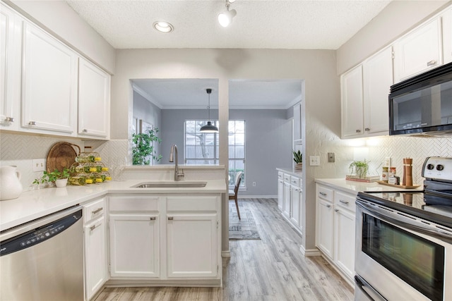 kitchen featuring white cabinets, stainless steel appliances, light countertops, and a sink