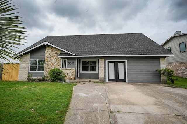 mid-century inspired home featuring brick siding, a shingled roof, fence, a front yard, and french doors