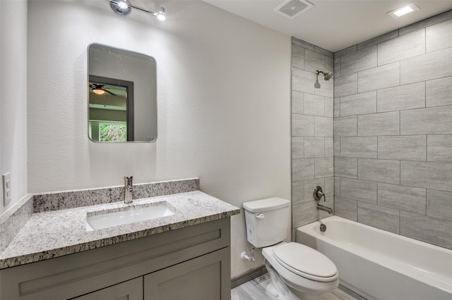 full bathroom with visible vents, toilet, shower / tub combination, ceiling fan, and vanity