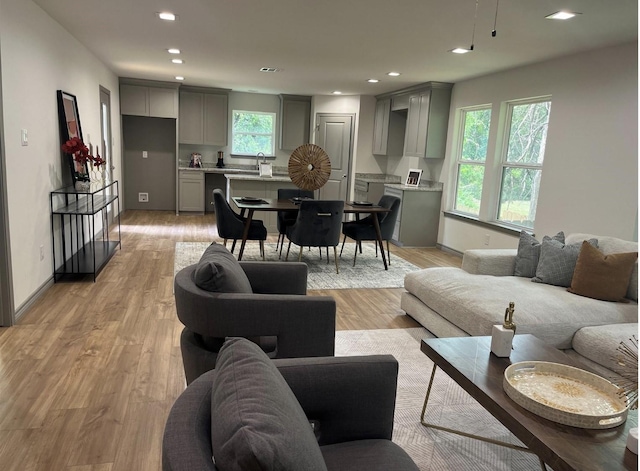 living room featuring recessed lighting, light wood-type flooring, and baseboards