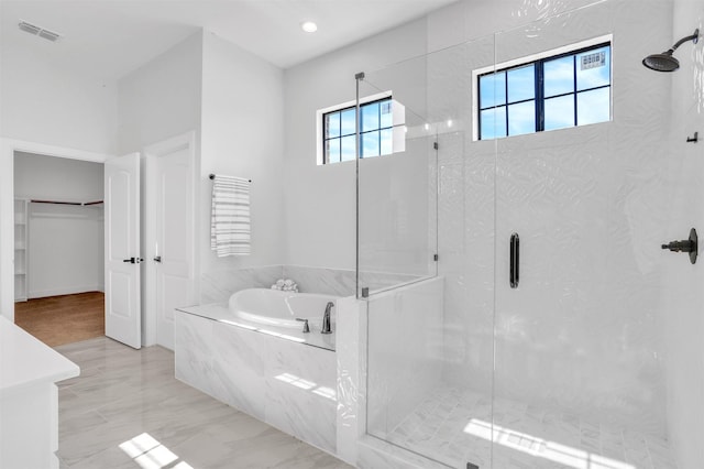 bathroom with visible vents, a garden tub, a walk in closet, and a shower stall